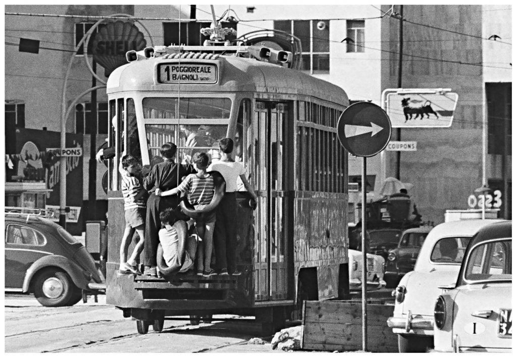 Scene in Italy: group of children free-riding the tram